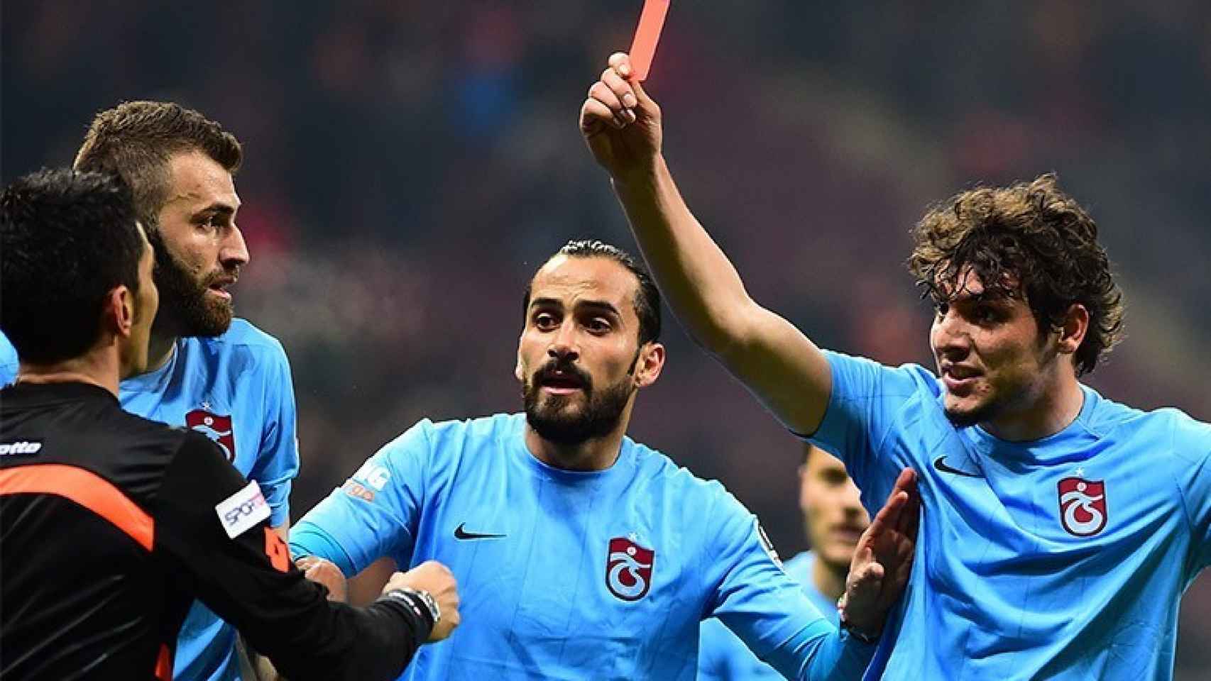 Un jugador del Trabzonspor enseña la tarjeta roja al árbitro.