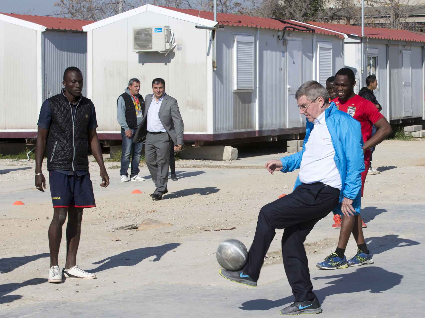 Thomas Bach, presidente del COI, juega con refugiados en Grecia.