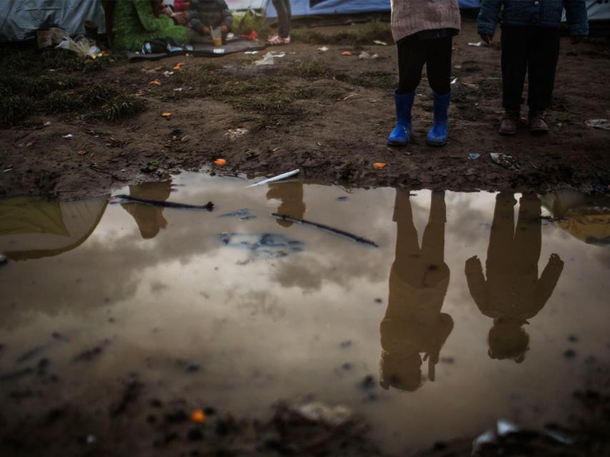 Niños reflejados en un charco en Idomeni.