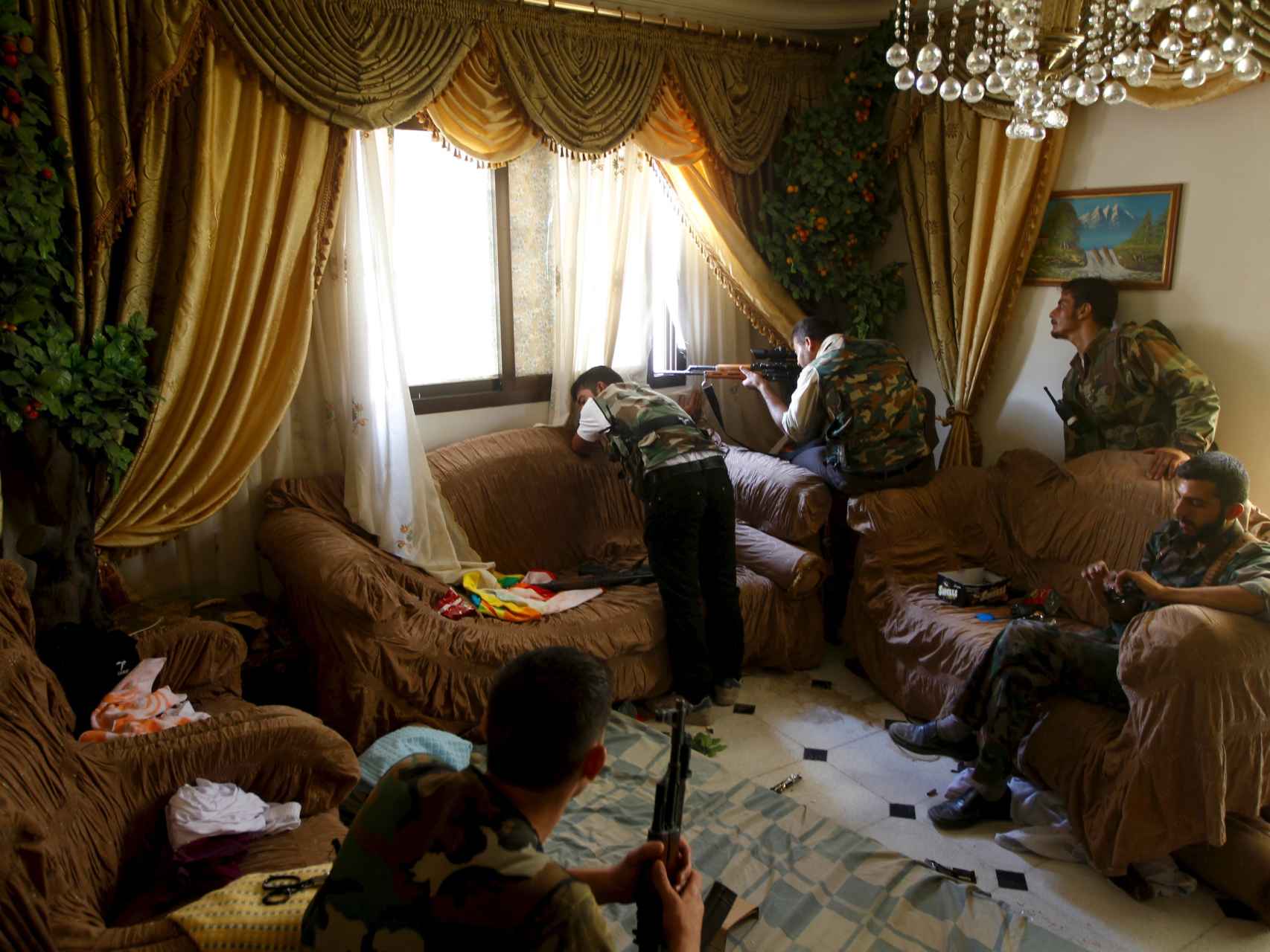 Un rebelde dispara desde una casa en Alepo.