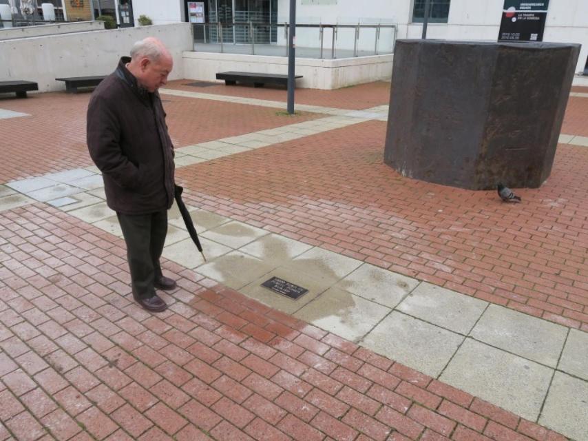 Un vecino descubre la placa que señala el lugar de la obra-tesoro.