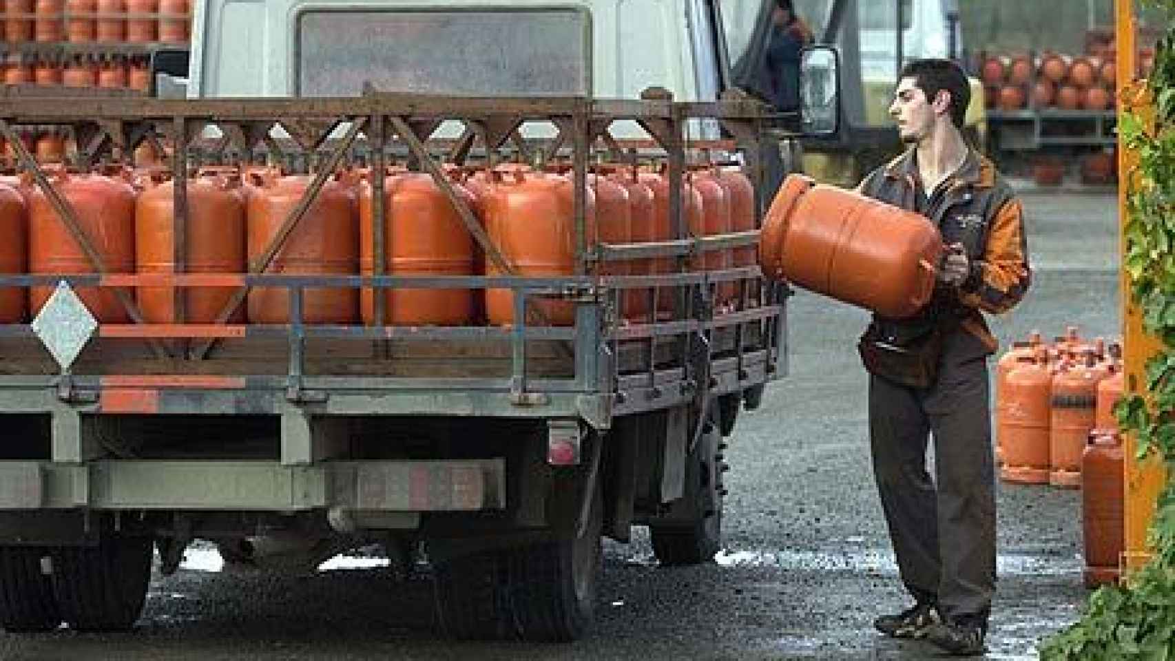 Una persona carga con una bombona de butano.