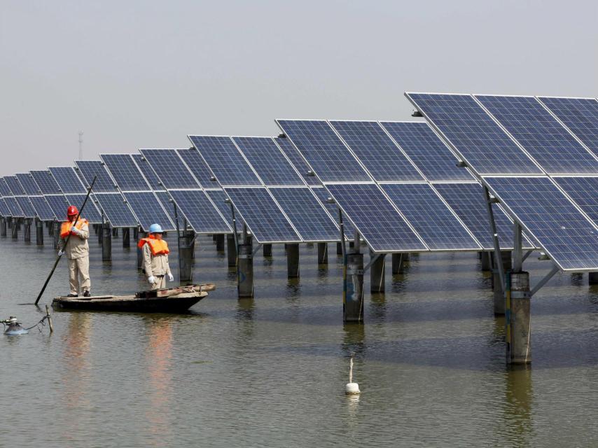 Operarios revisan paneles solares en China.