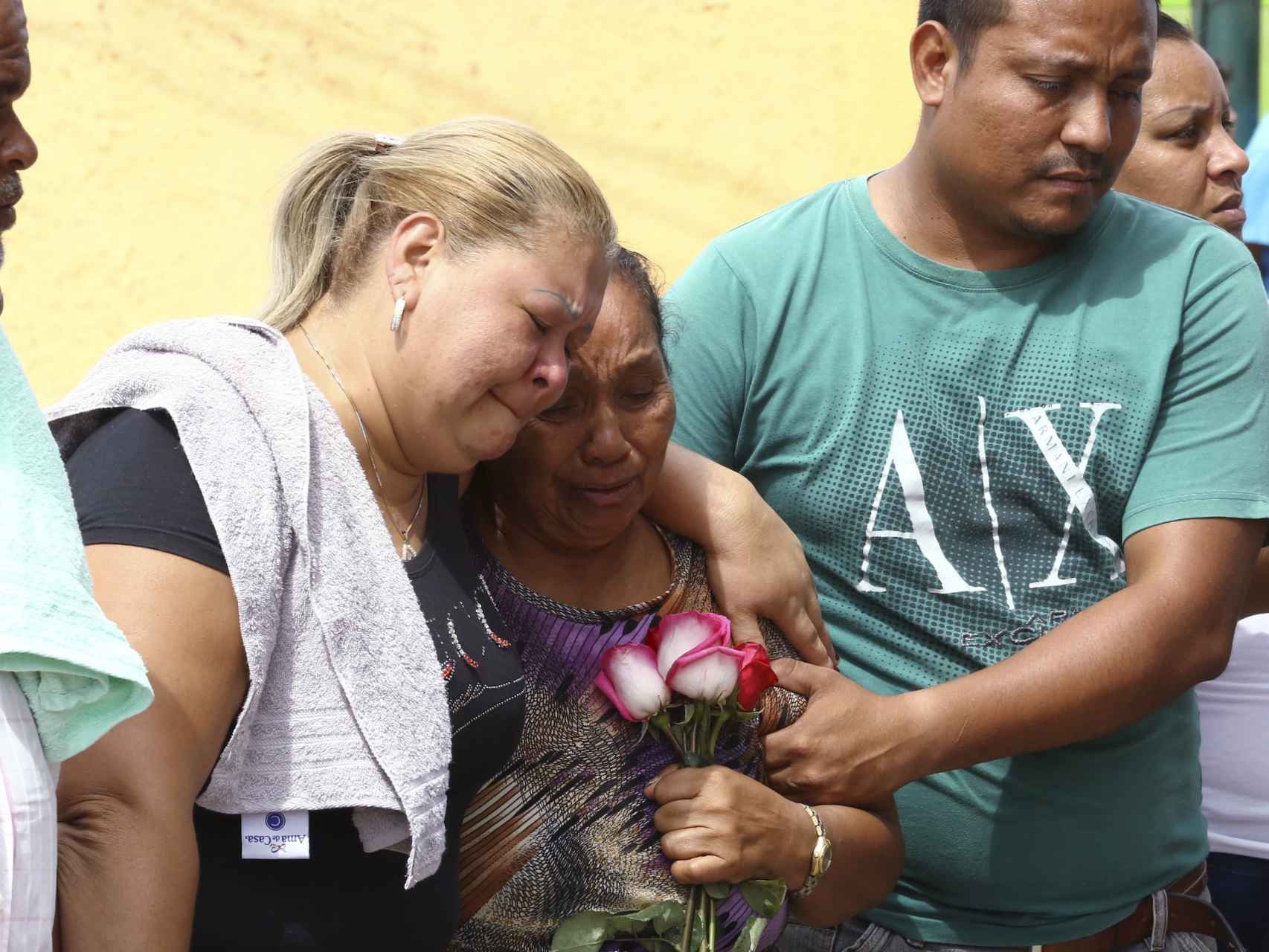 Familiares de un minero muerto lloran durante el entierro.