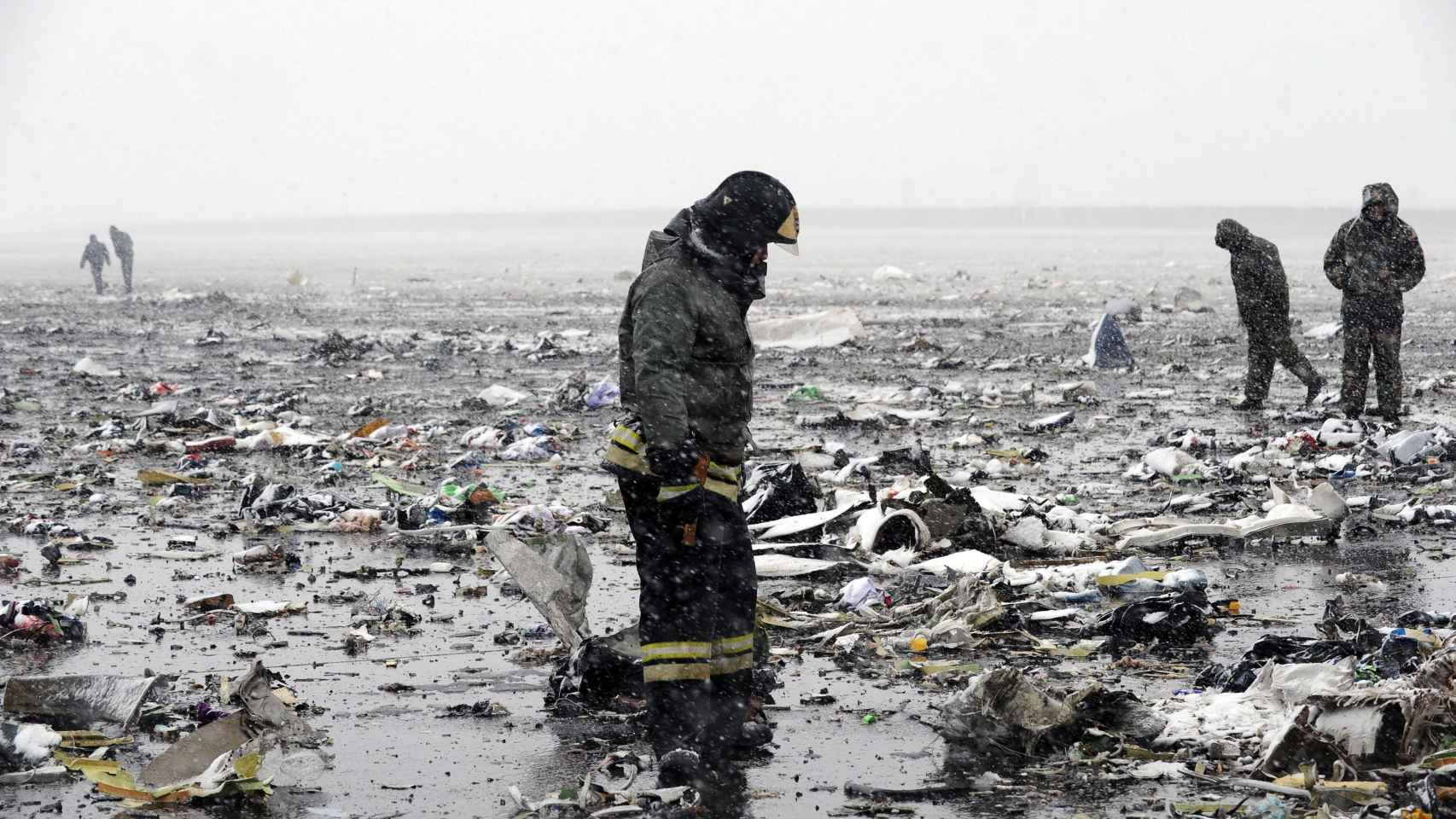 Un bombero busca las cajas negras entre los restos del avión.