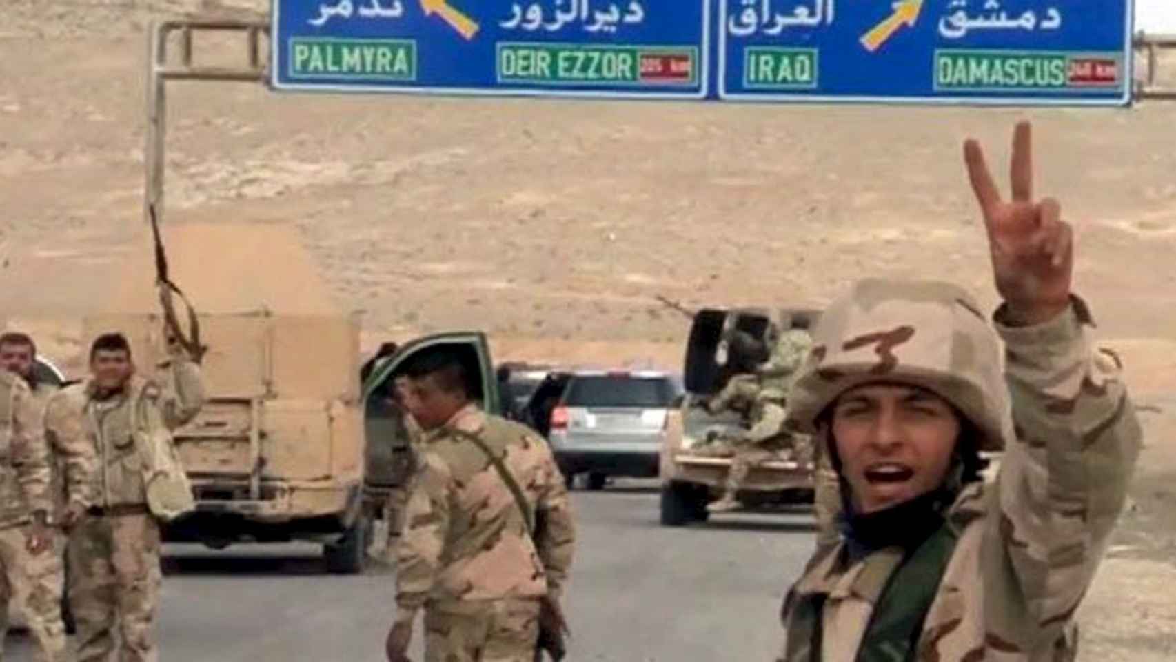 Soldados sirios hacen el signo de la victoria a su llegada a Palmira
