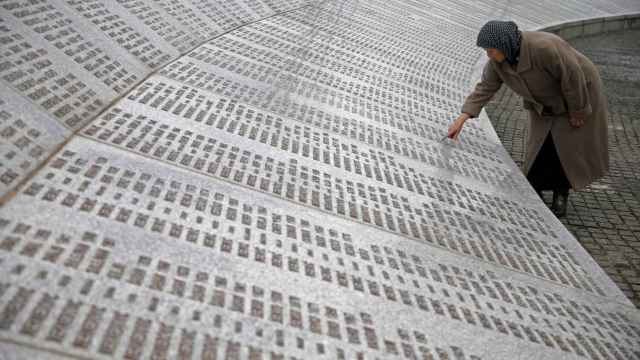 Una mujer busca entre los nombres de los muertos en Srebrenica.
