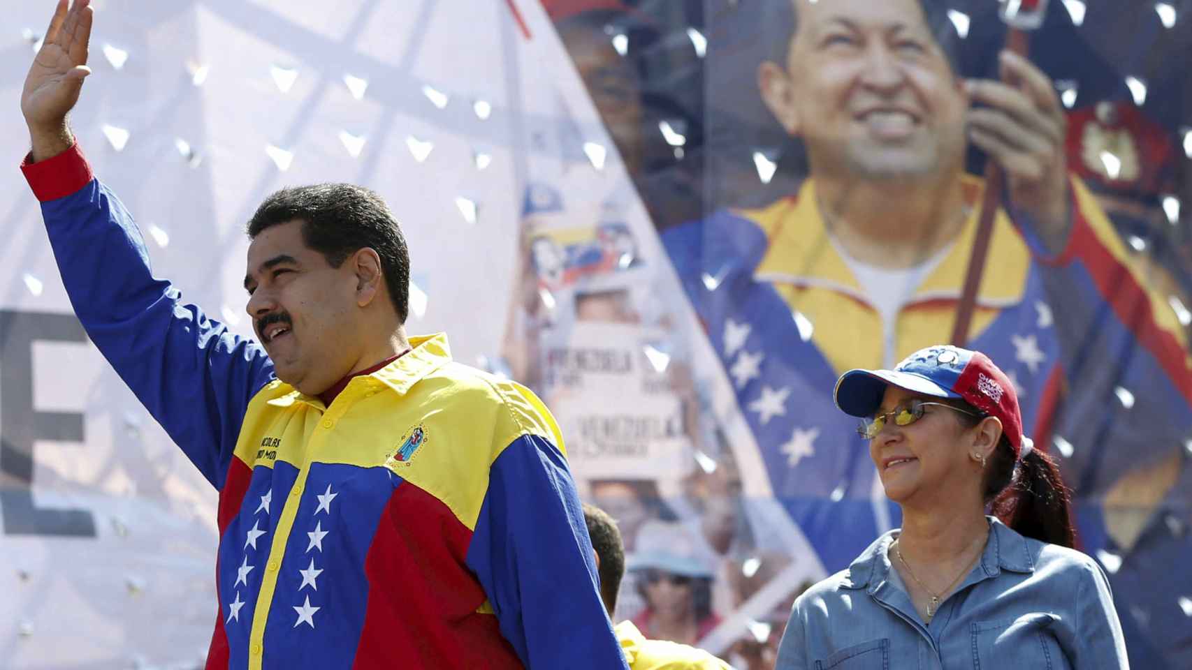 Nicolás Maduro y su mujer ante una imagen de Hugo Chávez