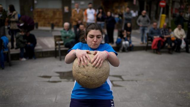 Una niña levanta una piedra.