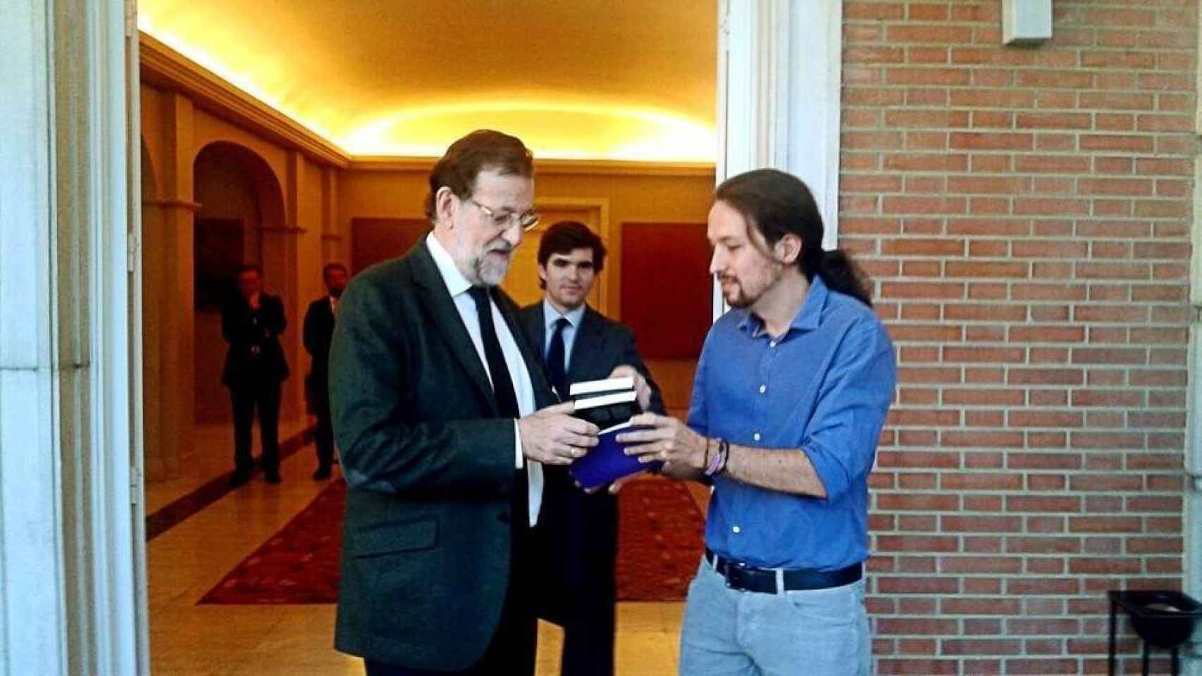 Pablo Iglesias regala un libro a Mariano Rajoy.