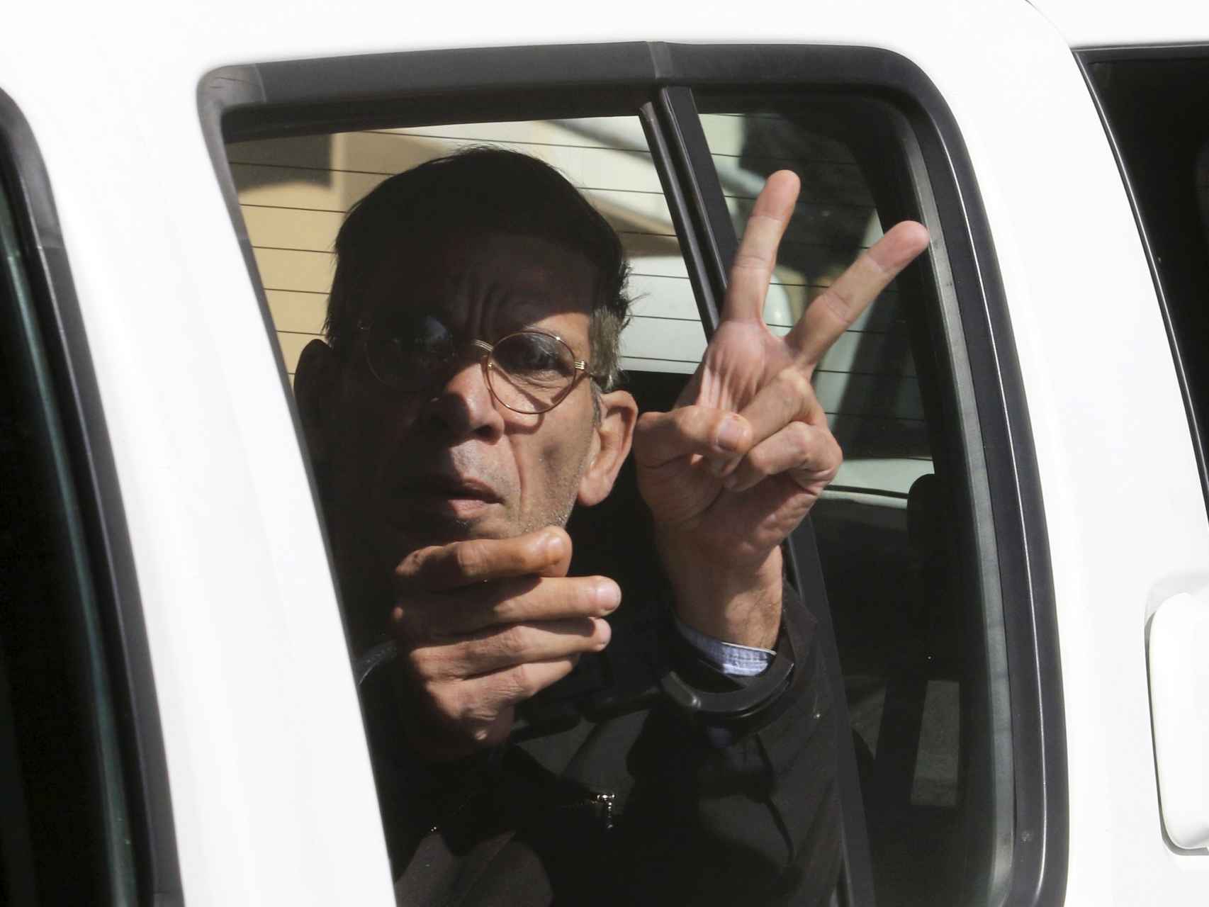 El secuestrador de Egypt Air muestra el signo de victoria cuando se lo llevan detenido.