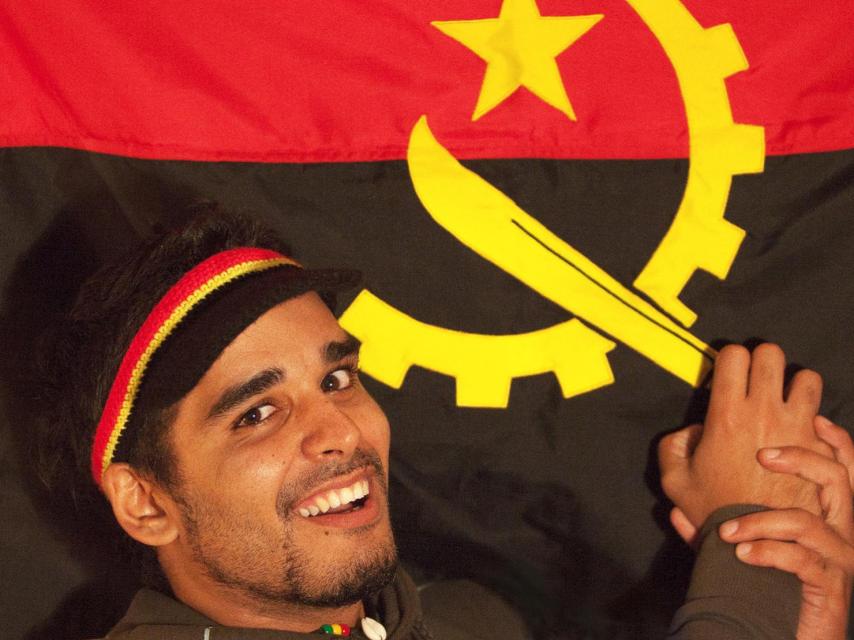 El activista Luaty Beirão junto a la bandera de su país.