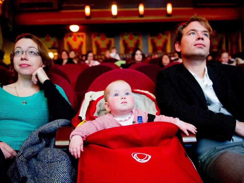 Una pareja disfruta de una película con su bebé en la sala de cine The Movies en Amsterdam (Holanda).