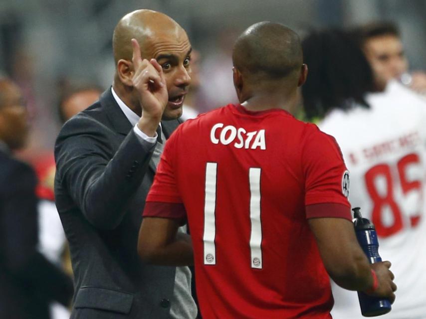 Guardiola da instrucciones a Douglas Costa.