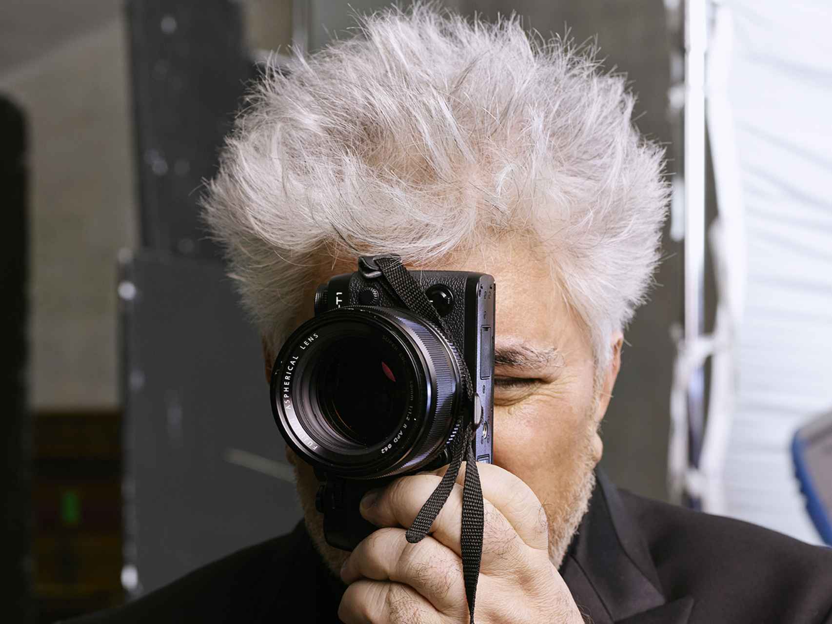 Pedro Almodóvar posa junto a su cámara de fotos.