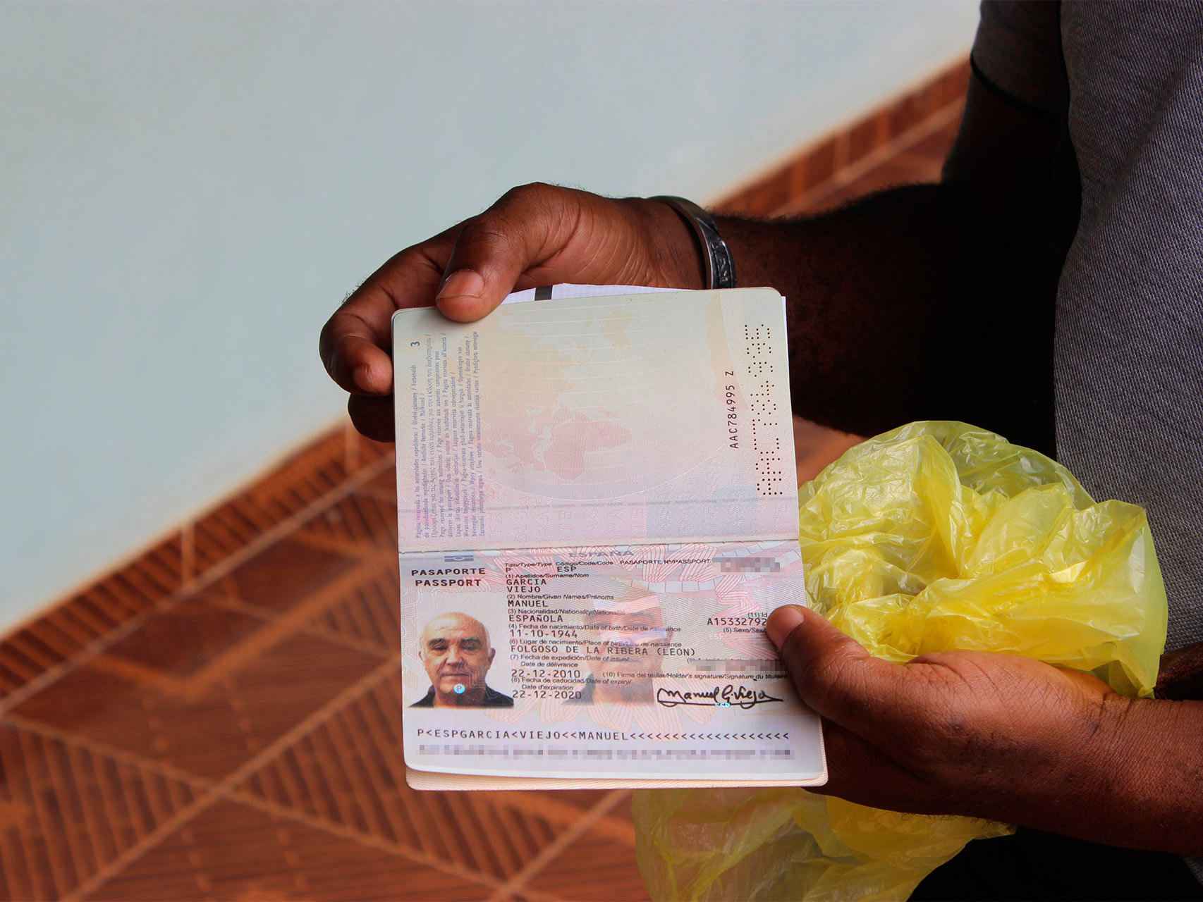 Un sacerdote muestra el pasaporte de Manuel García Viejo.