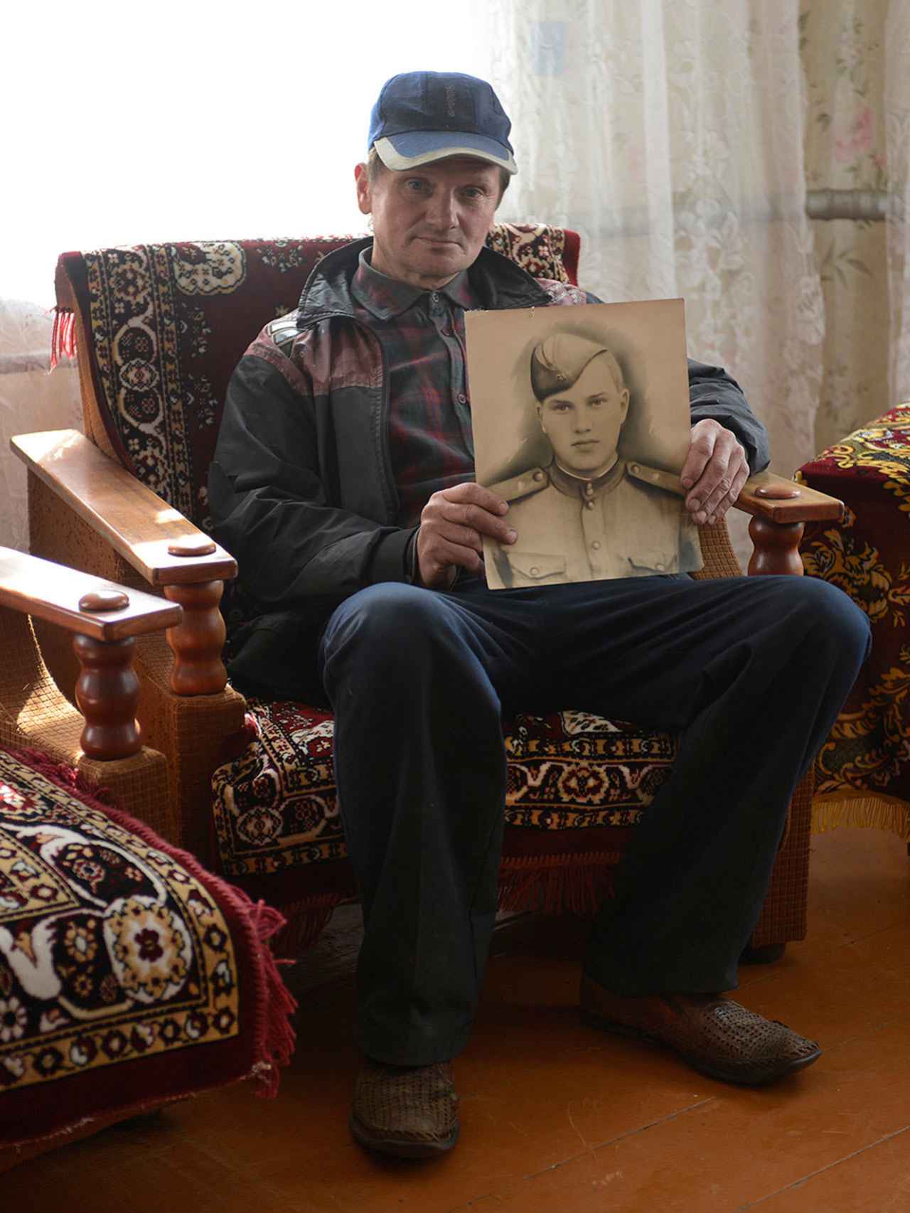 Sergey posa con un retrato de su padre, muerto por la radiación.