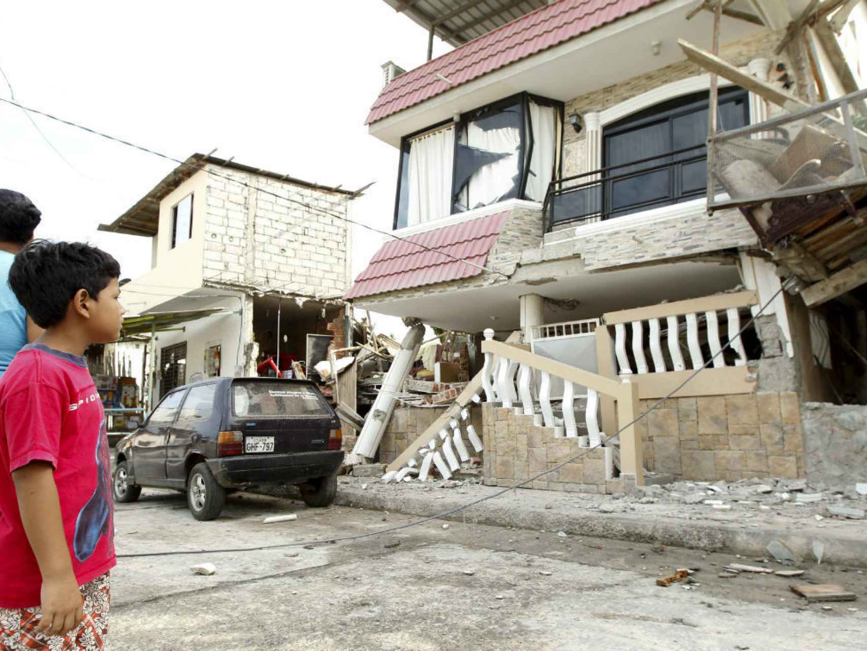 Un niño observa un edificio dañado en el barrio de Manta.