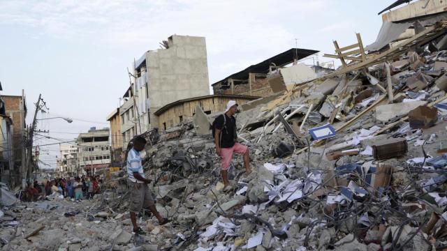 Los residentes de Portoviejo caminan entre las ruinas tras el seísmo.