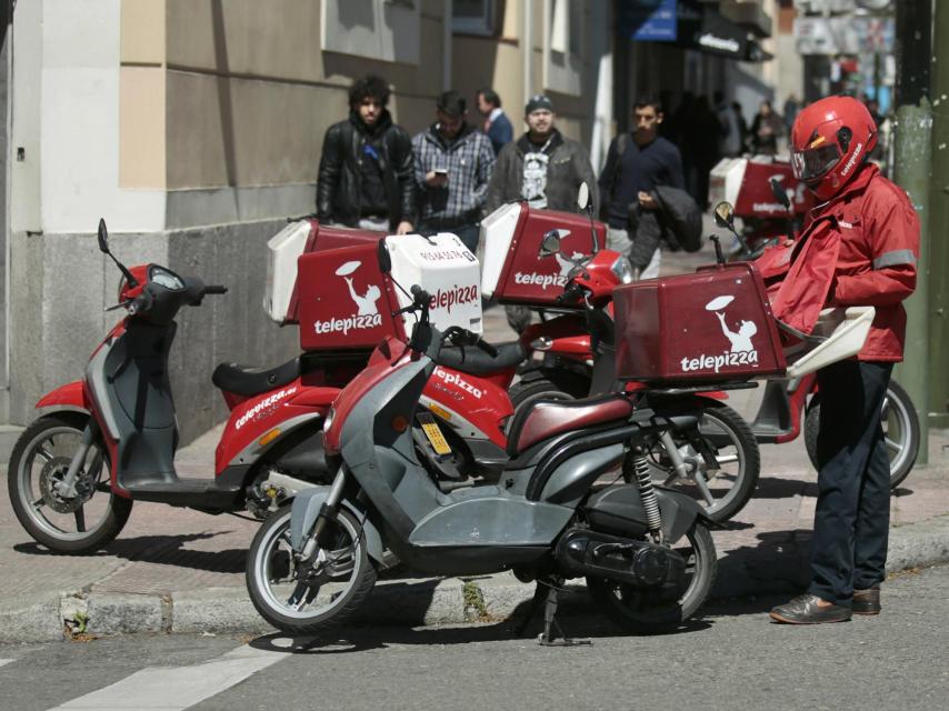 Un repartidor prepara su moto.