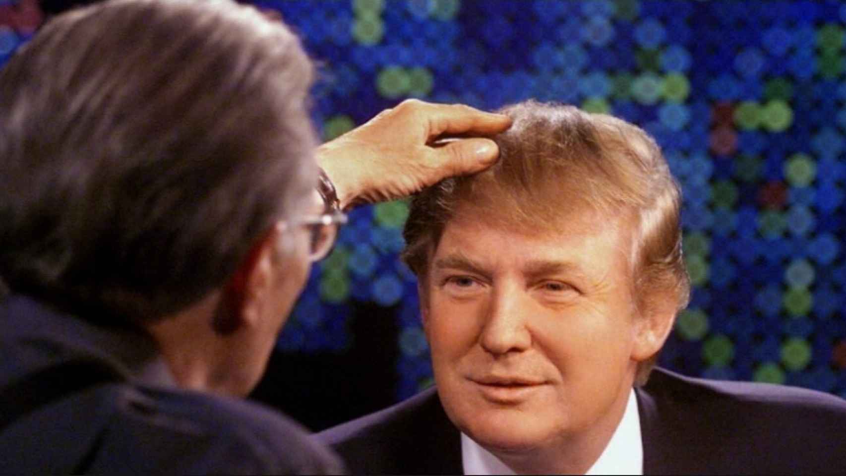 Larry King comprueba el pelo de Donald Trump en una entrevista