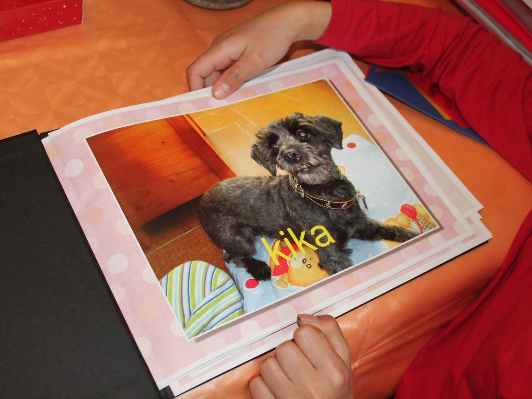 Foto de Kika en el álbum de adopción, la perra que ayudó a María en su proceso de adaptación a su nueva familia.