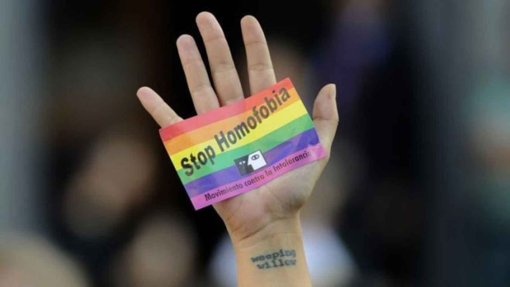 Un joven muestra una pegatina durante una concentración contra la homofobia en Madrid