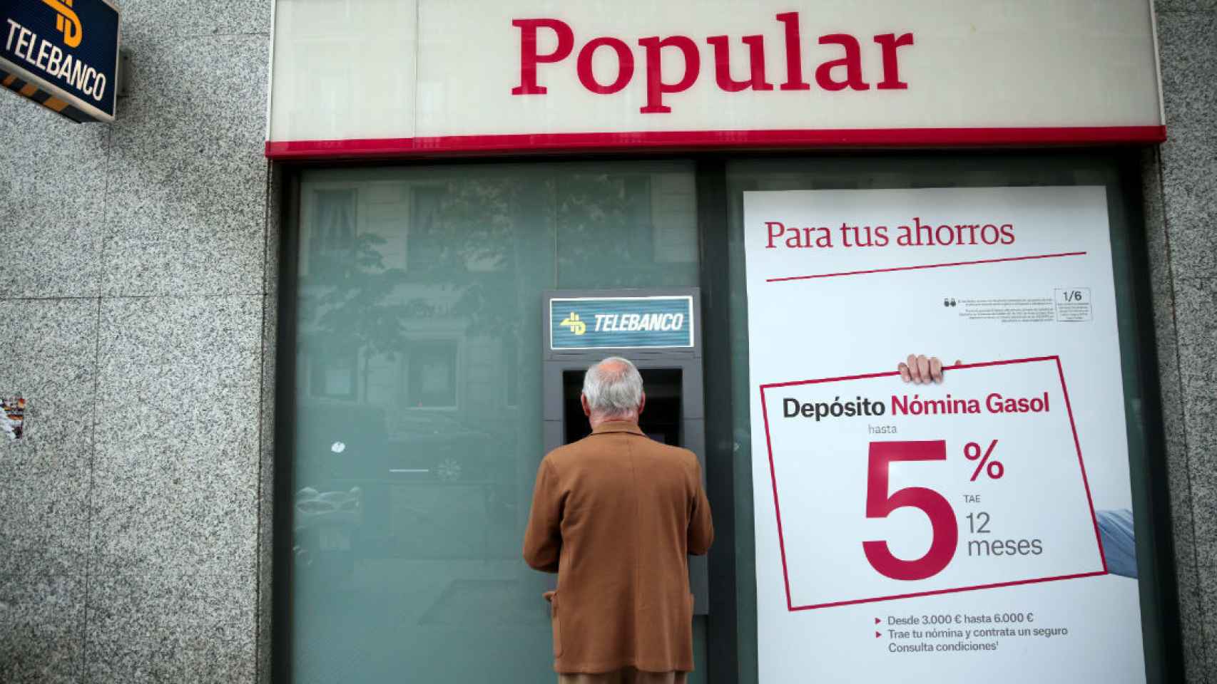 Un hombre saca dinero en un cajero en Madrid.