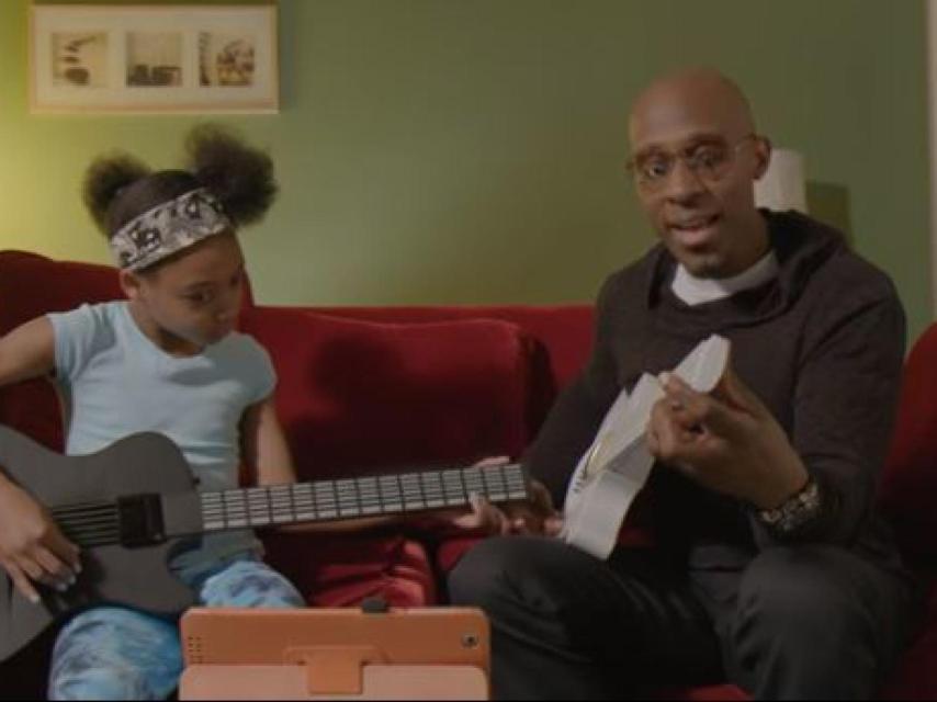 Padre e hija probando a tocar con la nueva guitarra del pianista Brian Fan.