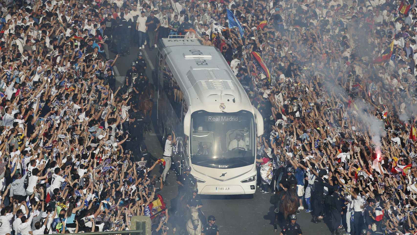 Aficionados del Real Madrid reciben al bus de su equipo.