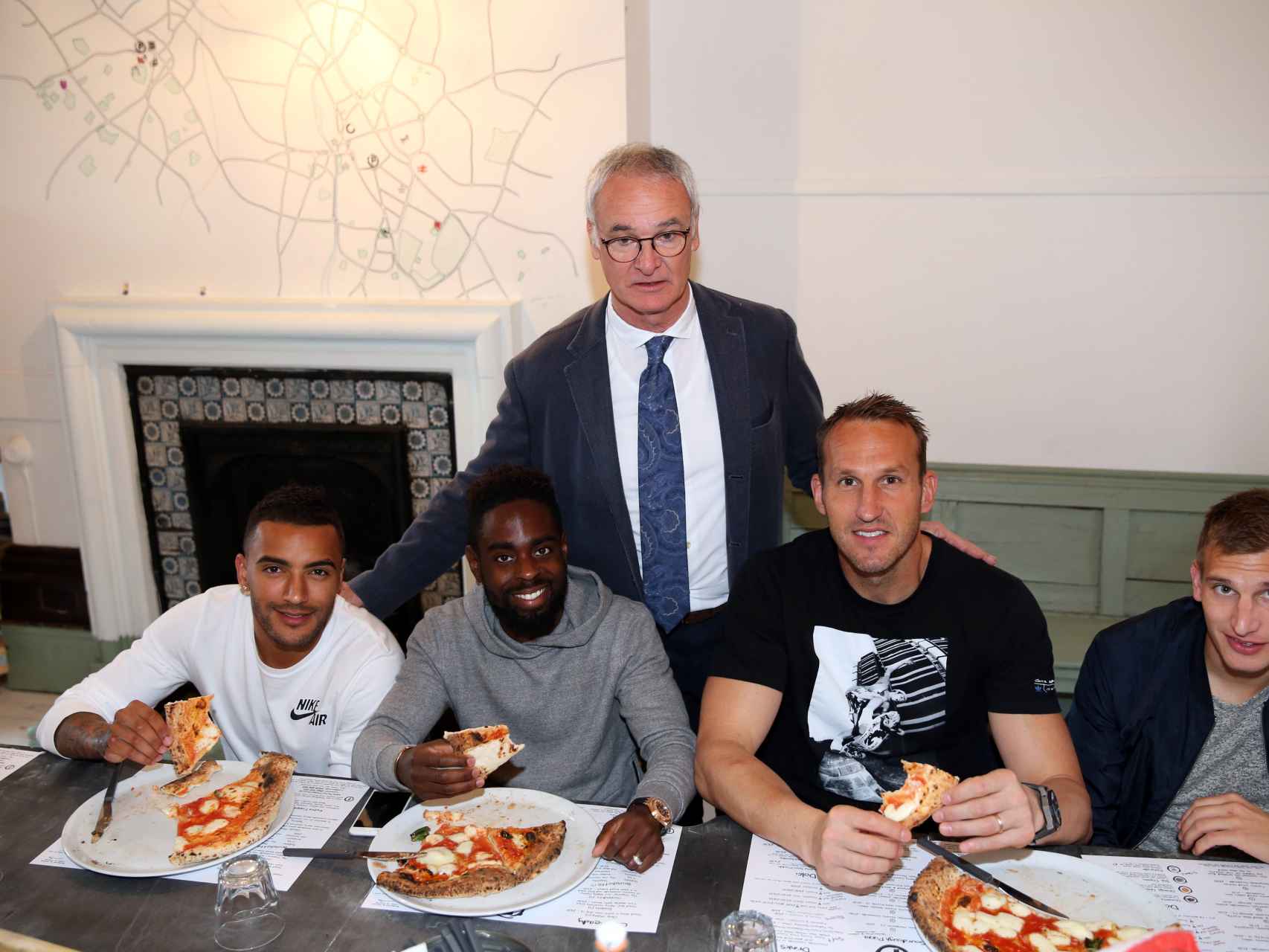 Los jugadores del Leicester comiendo pizza junto a Claudio Ranieri.