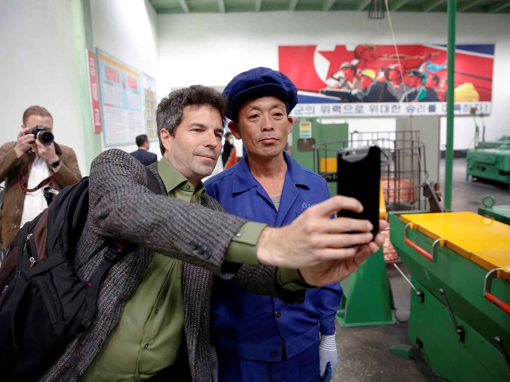 Un periodista extranjero se fotografía con un trabajador durante una visita organizada.