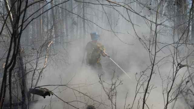 Un bombero trata de extinguir las llamas.