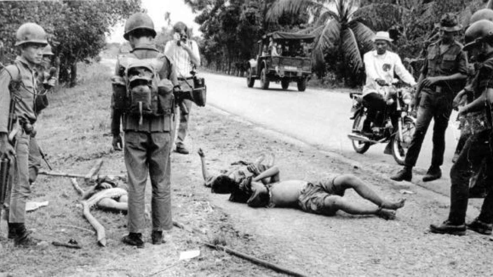 Múgica, fotografiando el cuerpo de un muerto durante la Guerra de Vietnam.