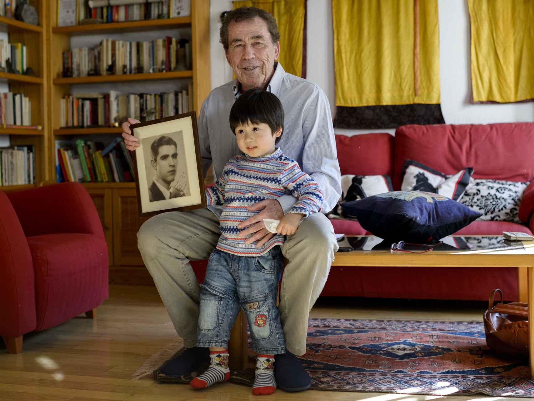 Sánchez Dragó posa junto a la foto de su padre y su hijo Akela.