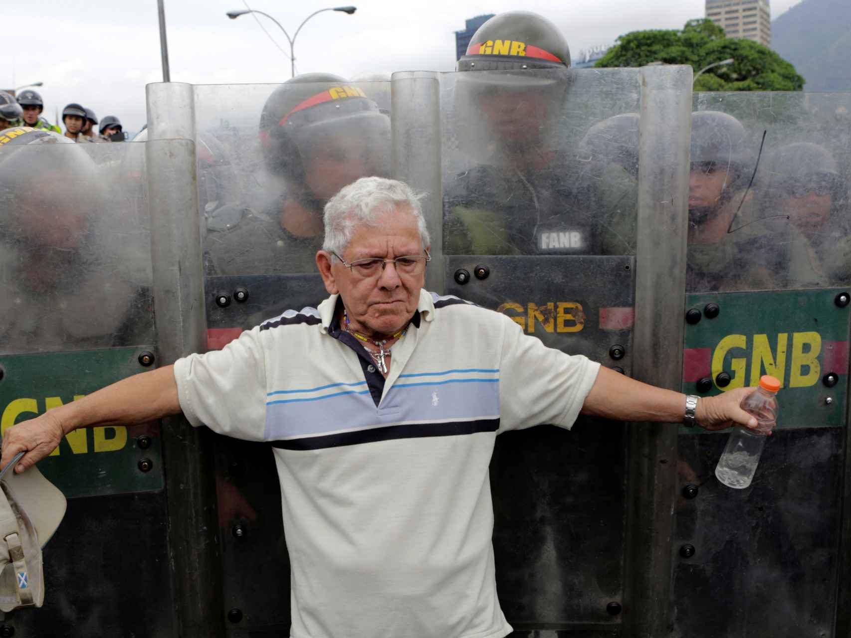 Un opositor se pone ante la Guardia Nacional durante una manifestación contra Maduro.