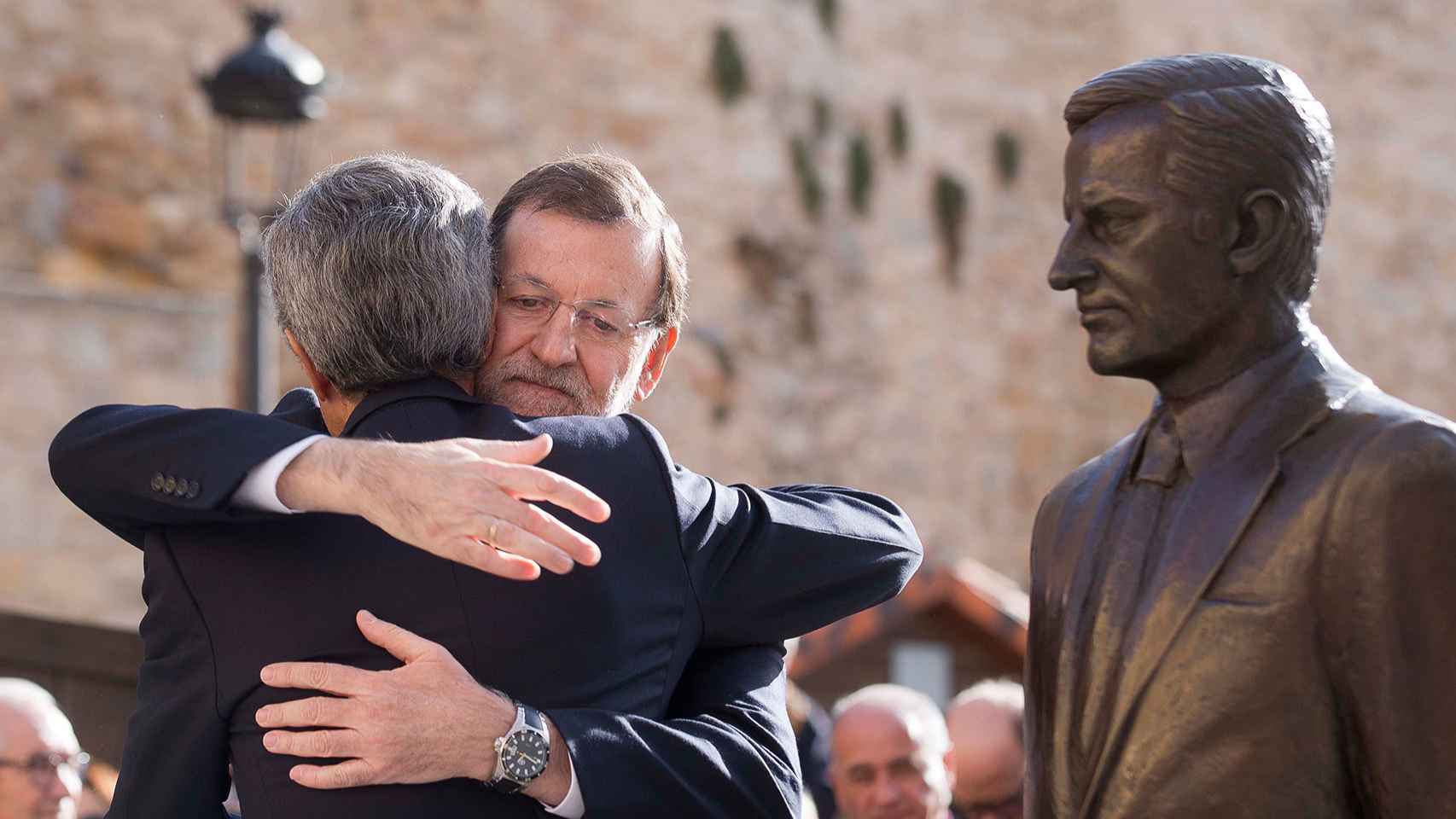 Rajoy y Suárez Illana abrazados ante la estatua del primer presidente.