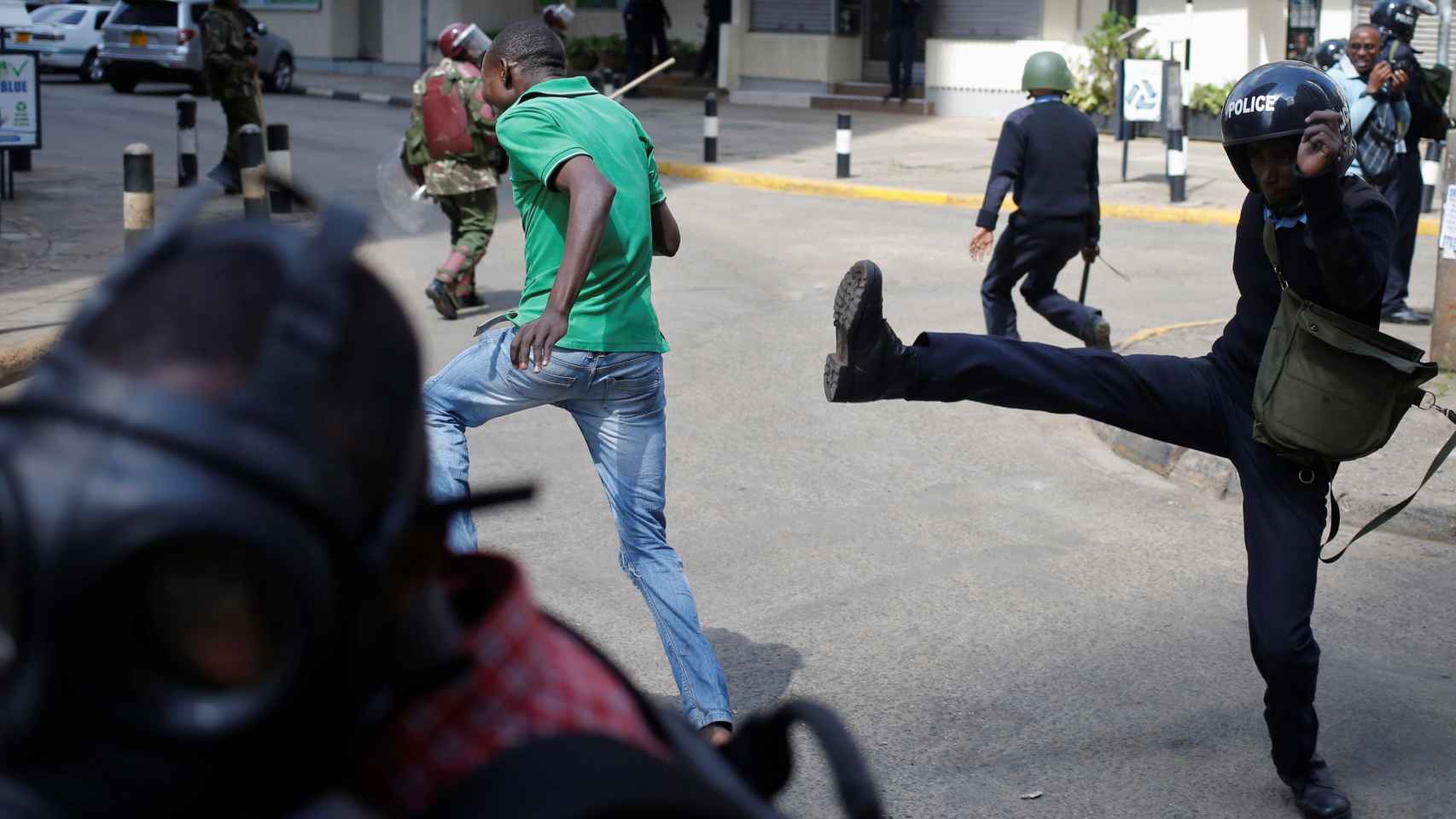 Un agente de los antidisturbios lanza una patada a los manifestantes