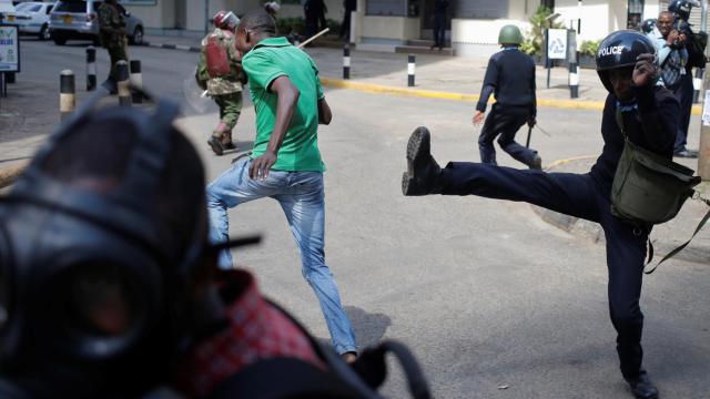 Un agente de los antidisturbios lanza una patada a los manifestantes