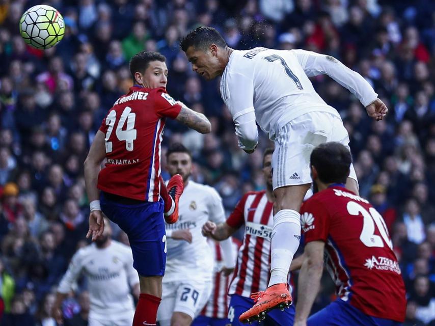 Cristiano Ronaldo remata de cabeza entre defensores del Atlético.