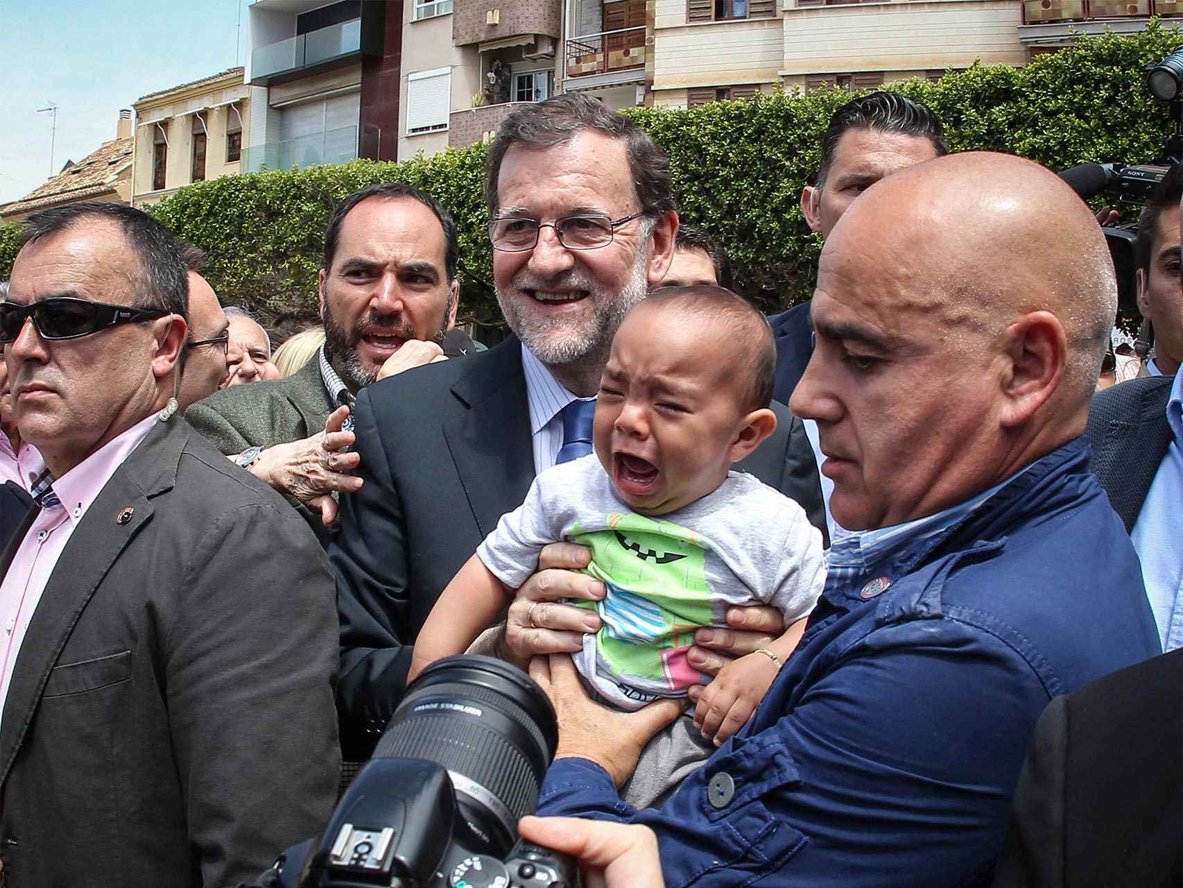 Un niño llora al hacerse una foto con Rajoy en Alfafar, Valencia.