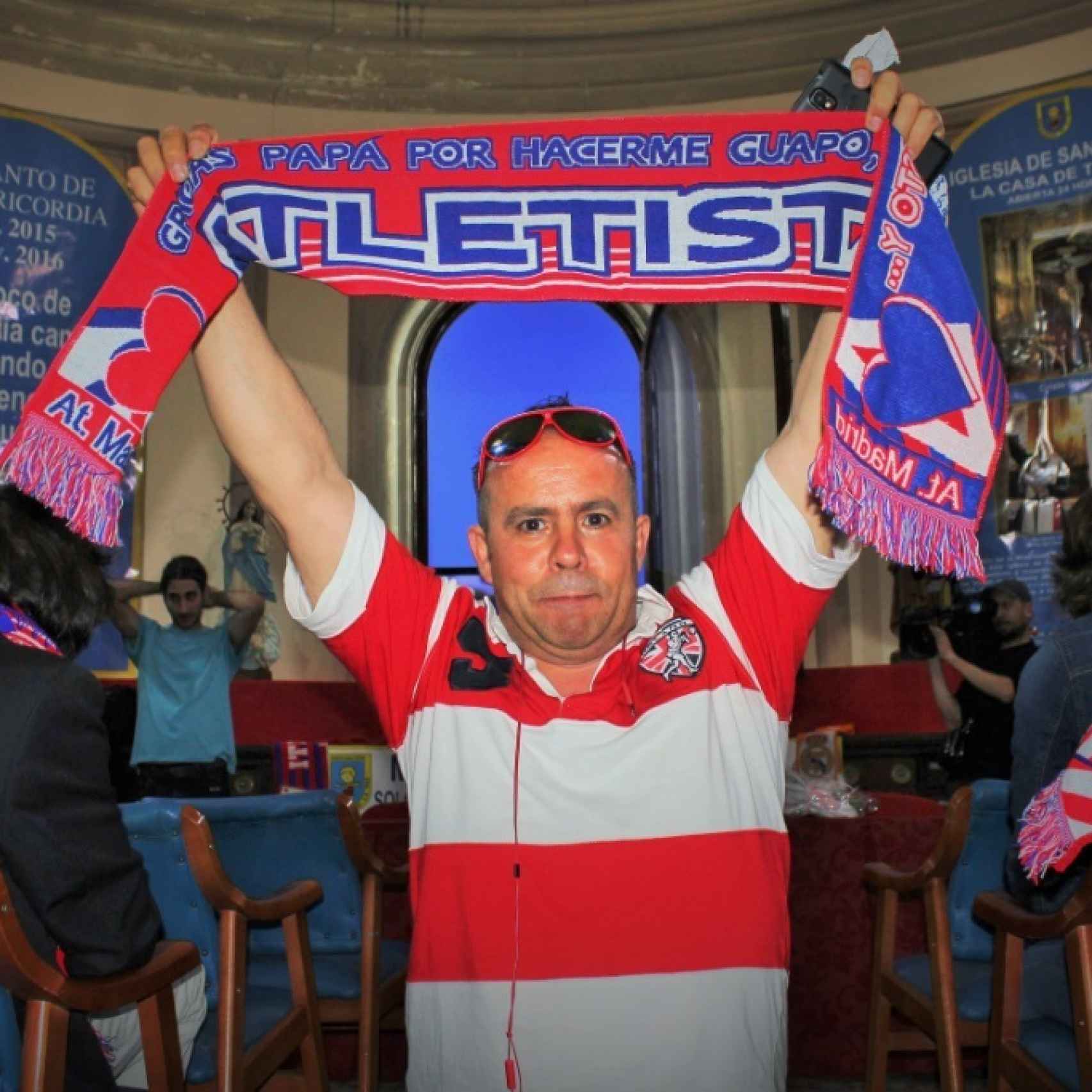 Un aficionado del Atlético de Madrid en la sala de la iglesia en la que se vio el partido.