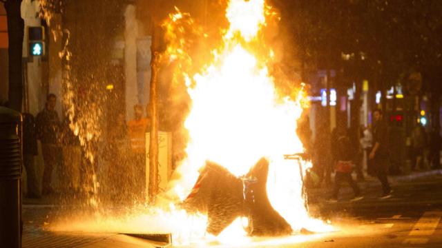 Contenedores incendiados en la calle Gran de Gràcia de Barcelona.