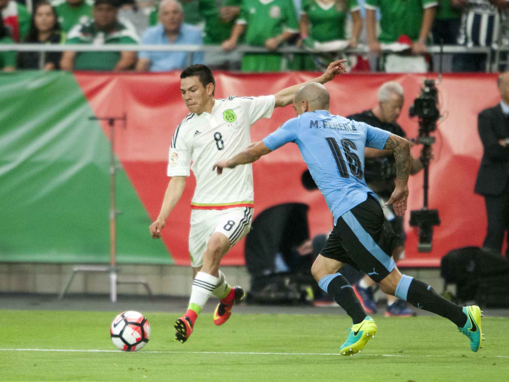 Hirving Lozano patea el balón ante Maxi Pereira, de Uruguay.