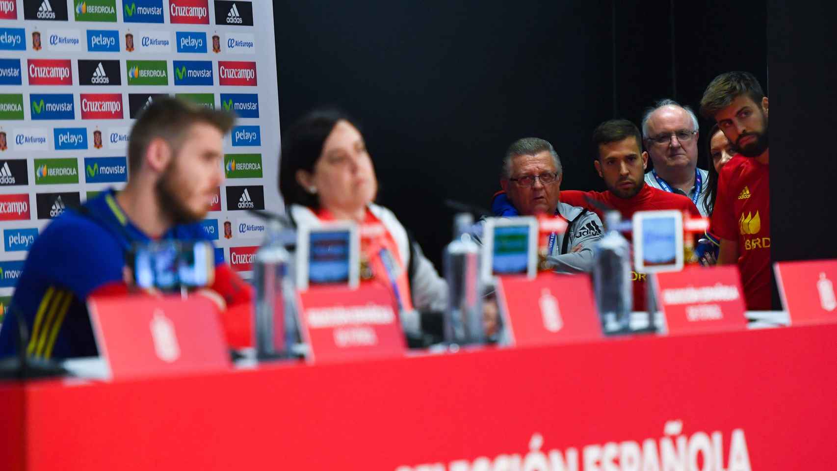Piqué, Jordi Alba y Pedro Cortés observan la rueda de prensa de De Gea.
