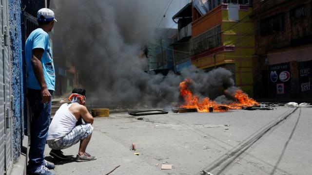 Manifestantes junto a una barricada en un enfrentamiento con la policía en el centro de Caracas