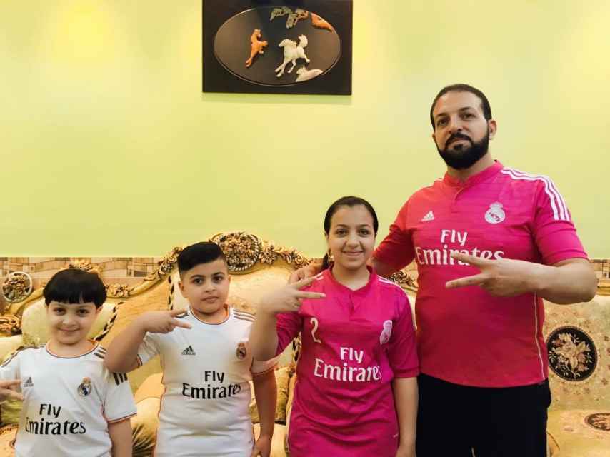 Qasim Znad, junto a sus hijos Marwa, Ali y Muhammad, en el salón de su casa en Balad (Irak).