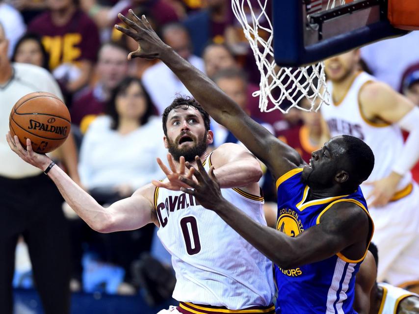 Draymond Green intenta taponar a Kevin Love.