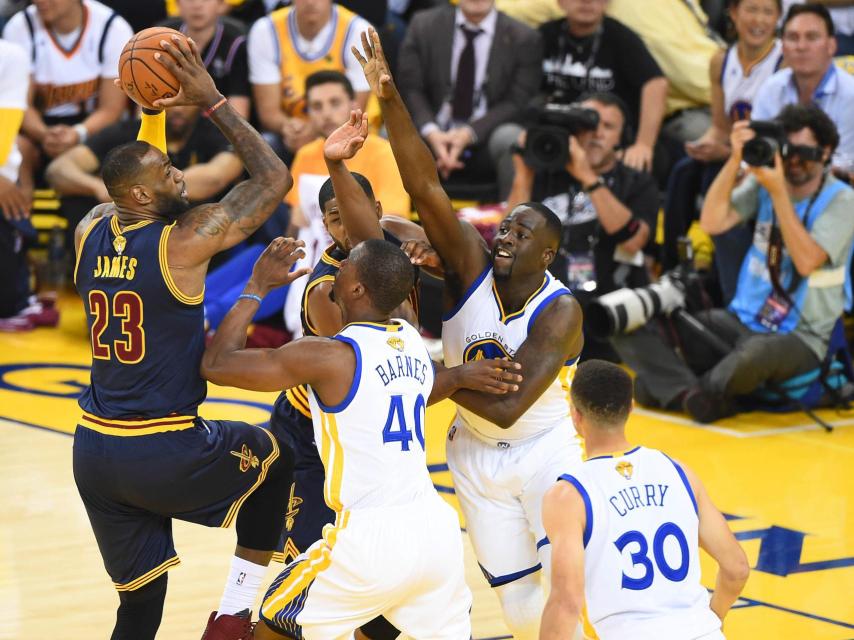 LeBron James rodeado por la defensa de los Warriors.