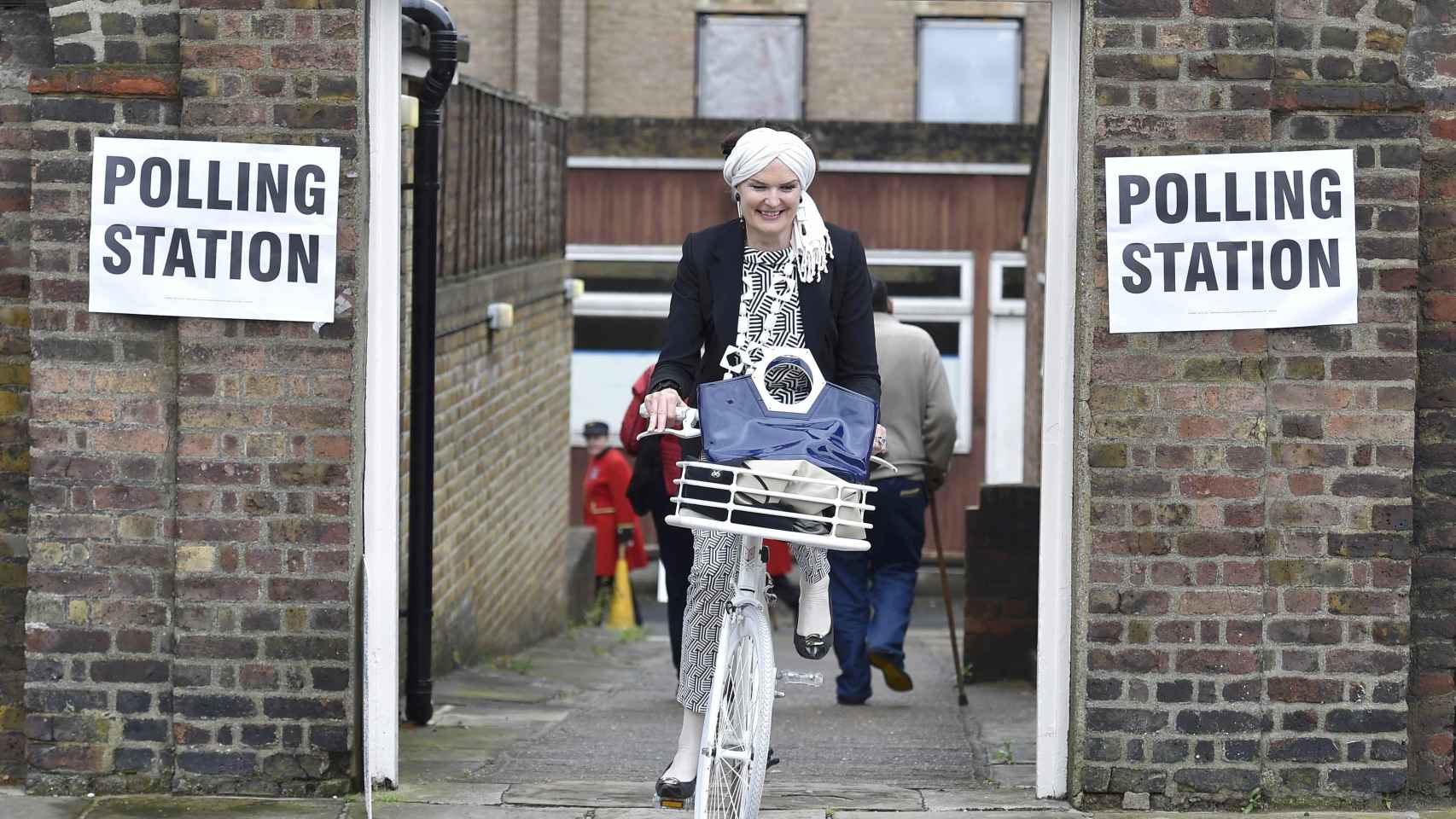 Una mujer sale en bicicleta tras votar en un colegio electoral de Chelsea en Londres.